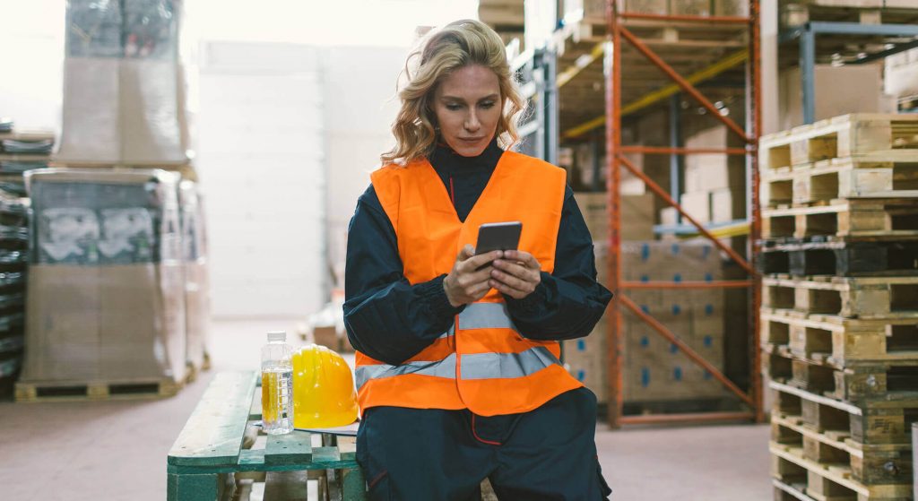 teamapp_woman-in-warehouse-checking-phone_iStock-682509636